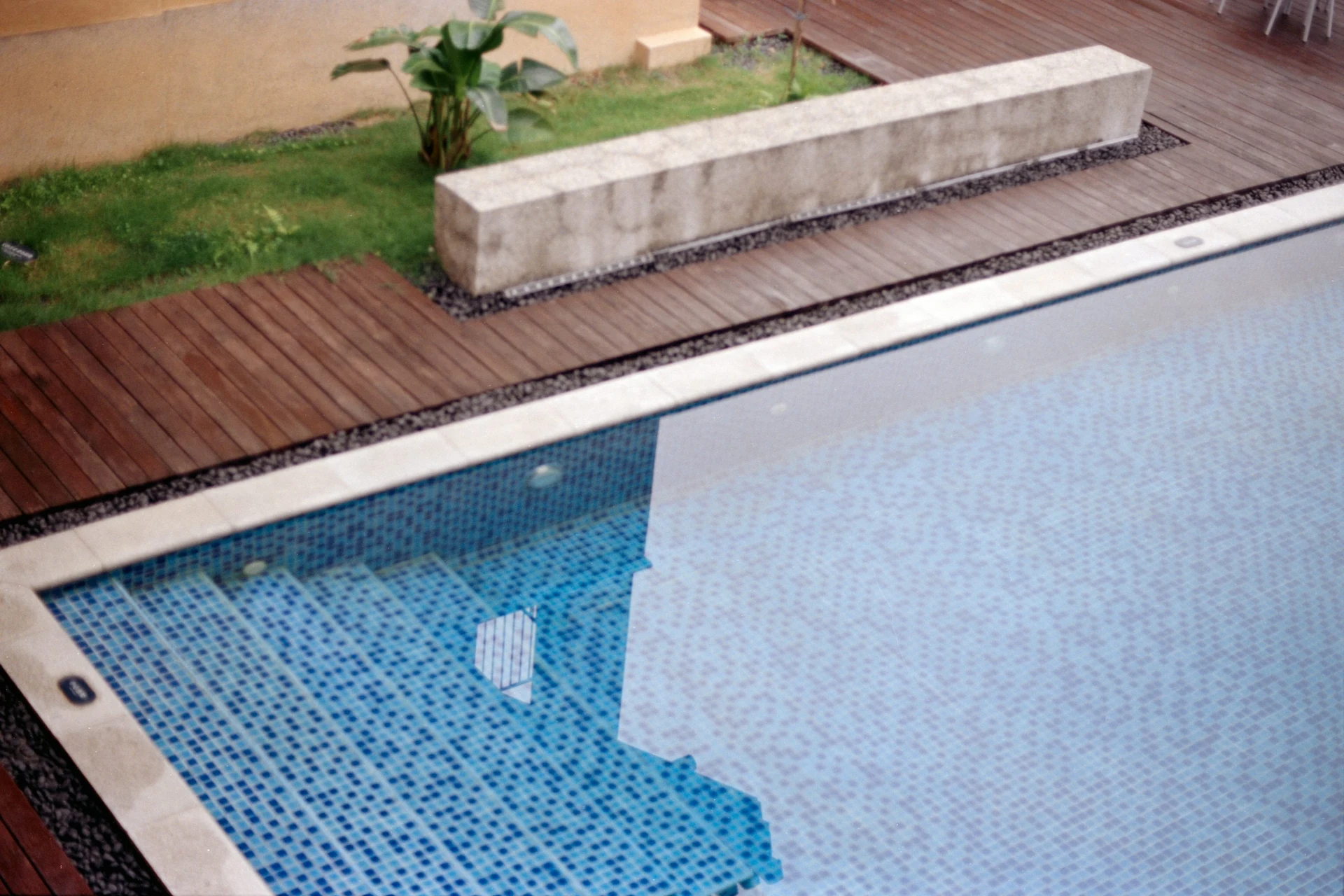 Pooltreppe mit Mosaikfliesen neben einer Holzterrasse