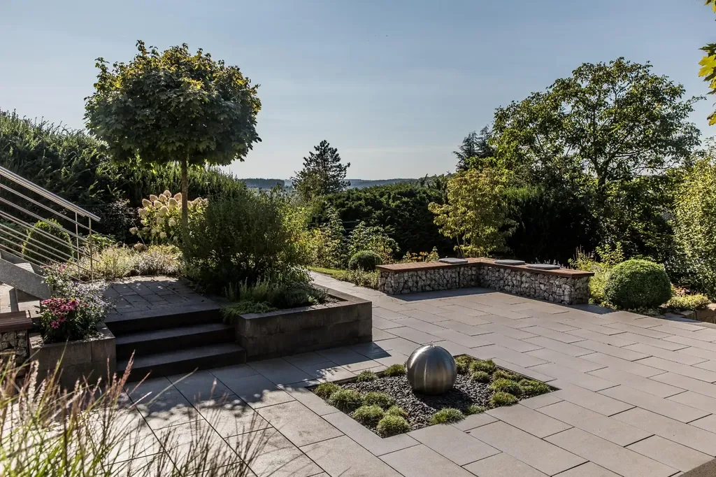 Hanggarten mit Terrassenflächen und Natursteinmauern